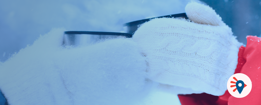 Paire de gants d’hiver tenant une tasse chaude dans une ambiance hivernale, illustrant les visites et activités touristiques en France en hiver avec les City Pass et Pass touristiques disponibles sur Pass France.